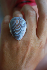 Close-up of a hand wearing a ring with a blue lace agate stone.